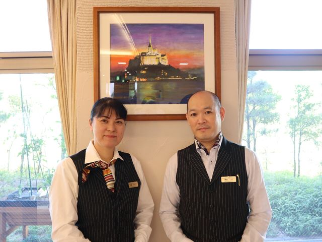 スタッフ二人と絵画のロビー スタッフ 落ち着いた雰囲気のロビーで笑顔のスタッフが迎えてくれます。皆さまの快適な生活を支える心強い存在です。