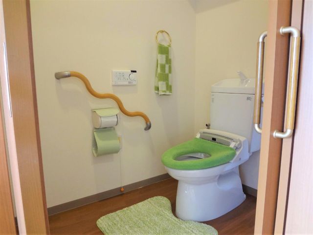 手すり付きトイレの内観 トイレ 手すりが設置された安心設計のトイレです。清潔感ある空間で、快適にご利用いただける工夫がされています。