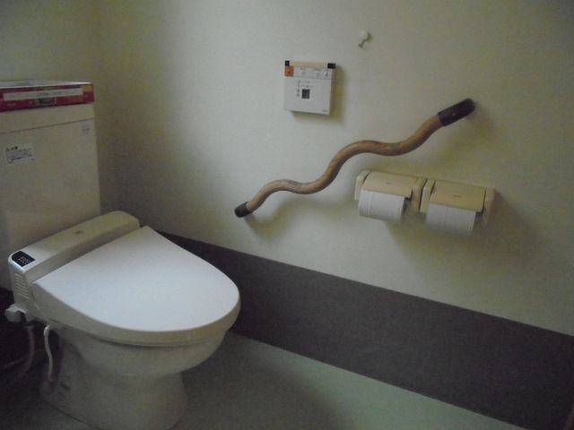 手すり付きのトイレ トイレ 手すりが設置され、安全で使いやすいトイレです。落ち着いた色調でリラックスできる空間です。