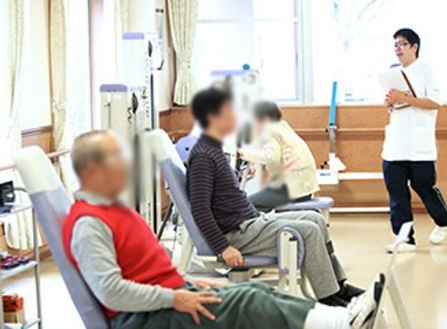 機能訓練室の体操 機能訓練室 広々とした訓練室で、利用者がリハビリに励んでいます。明るい空間では指導員のサポートが受けられます。