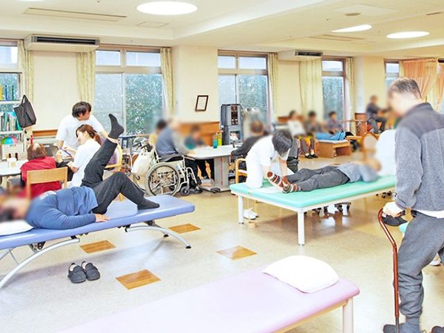 機能訓練が行われる場所 機能訓練室 明るい広々とした空間で、利用者がリハビリを行う様子です。自然光が差し込む環境になっています。