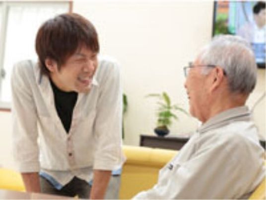 笑顔で会話するスタッフと高齢者