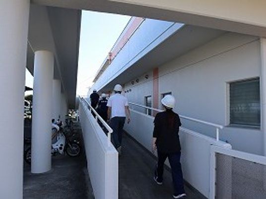 屋外通路を歩く人々と自転車  