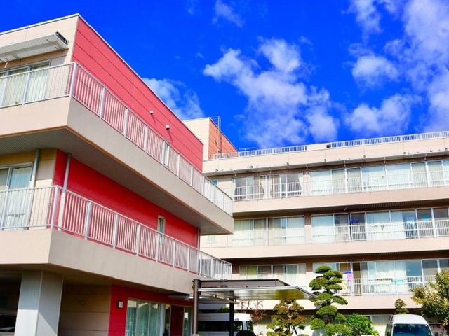 青空の下の建物外観 外観 広々とした建物に囲まれた空間です。青空のもと、快適な作業環境を提供します。