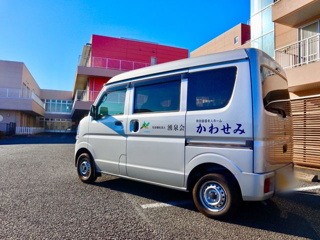 福祉車両と建物の外観 外観 福祉用の車両が停まる広々とした施設の外観です。利用者の送迎に対応できる設備が整っています。
