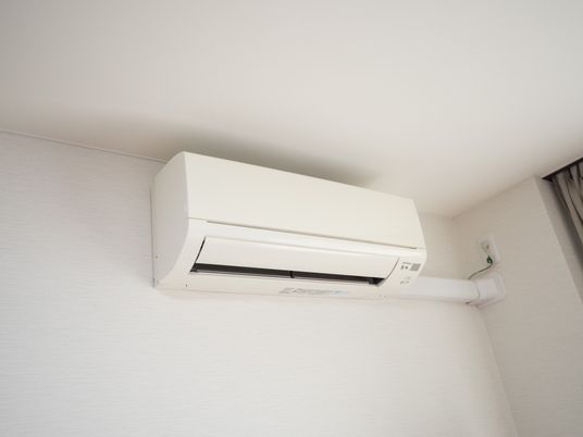 天井近くにエアコンが取り付けられている。配管は全て、天井付近にされているため、生活する上で邪魔にならない。