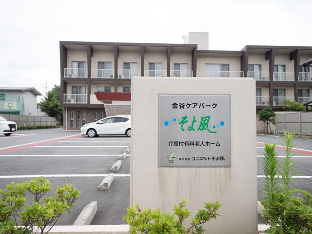 施設の看板と外観 駐車場 清潔感のある建物が印象的な一角です。安定した環境で働きたい方には理想的な職場かもしれません。