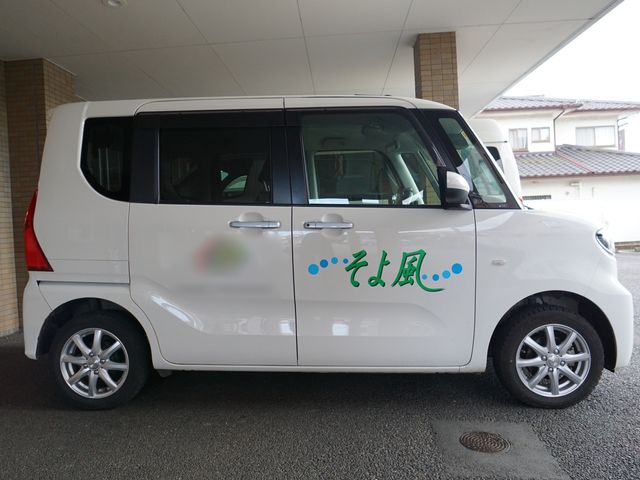 白い送迎車の側面 車 柔和な色使いの送迎車が、ご利用者様の快適な移動をサポートしています。安心してご利用いただける車両の一部です。