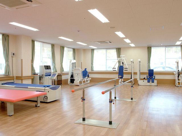 充実した設備の機能訓練室 機能訓練室 広々としたスペースには、各種リハビリ用機器が揃っており、明るく清潔な環境です。