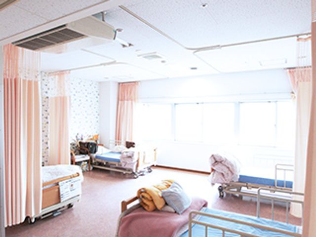 明るい多床室 居室 広々とした病室で、一人ひとりが過ごしやすい空間が確保されています。自然光が心地よく差し込む環境です。