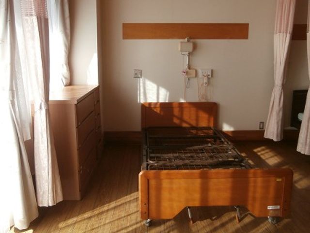 日差しの入る居室 居室   大きな窓から自然光が入り、木目調の落ち着いた居室です。ベッドまわりがすっきりしていて、働く方も様子を把握しやすそうです。