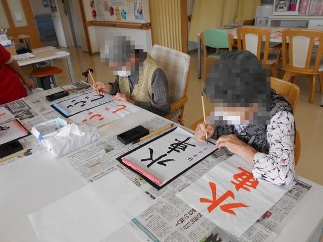 書道を楽しむ参加者のラウンジ ラウンジ 自然光の差し込むラウンジにて、利用者が書道を楽しむ様子です。リラックスした時間を提供します。