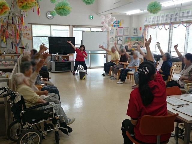 体操の様子の居室 居室 広々とした部屋での体操活動です。和やかな雰囲気の中、皆さんで楽しく体を動かしています。