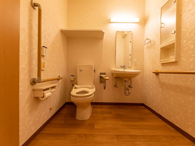 バリアフリー設計のトイレ トイレ サポート用の手すりが備えられた安全に配慮したトイレです。清潔感のある空間で安心してご利用いただけます。