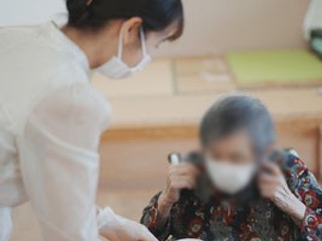 お茶を提供する様子 リビング テーブルでお茶を提供する姿が見られ、利用者の安らぎの空間になっています。