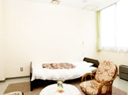 ベッドや椅子、テーブルなどが置いてある小さな部屋の様子。施設内の居室のデザイン