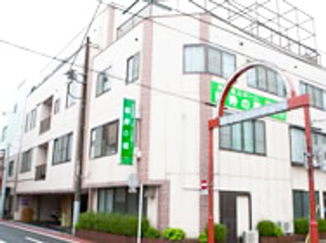 都市型施設の外観 外観 朱色のアーチと緑の旗が目印の建物で、街中に調和する清潔感のある外観です。落ち着いた周囲の環境との一体感も感じられる設計となっています。