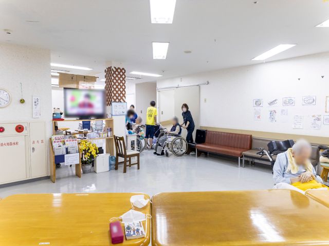 多機能空間と利用者 共有スペース スタッフが利用者の移動をサポートしており、共有スペースは清潔で明るい印象です。