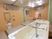 サムネイル 施設の写真 広い浴室で、特殊寝台が置いてあっても、洗い場には十分なスペースがある。シャワーの隣には、備え付けの棚がある。