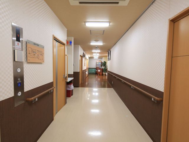 清潔な廊下の様子 通路 手すりが設置された広々とした廊下です。壁には案内板も備えられており、安心して移動ができるようになっています。