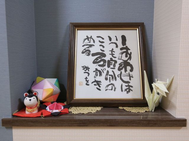 和風装飾のある棚 掲示物 温かみのある和風の装飾で、心穏やかな日々を過ごすための空間が演出されています。美しい手作りの折り紙も活用され、訪れる方々に和の心地よさを提供しています。