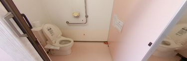 手すり付きの広々としたトイレ