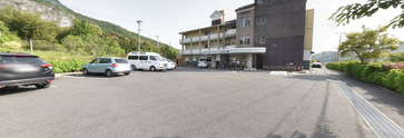 緑の中の広い施設外観と駐車場