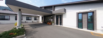 明るい介護施設の外観と庭