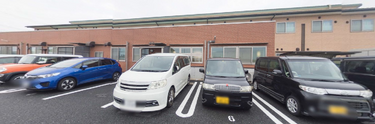 施設の外観と駐車場を示す風景