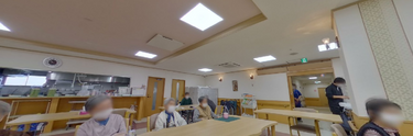 介護施設の共有スペースとスタッフ