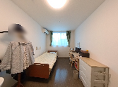 居室の洗面台とベッド  