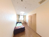 居室のベッドと収納がある部屋  