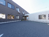 広々とした駐車場の施設外観