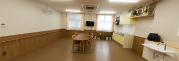 介護施設内の明るい廊下とリビング