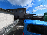 青空と駐車場の外観