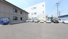 施設外観と駐車場を捉えた外景